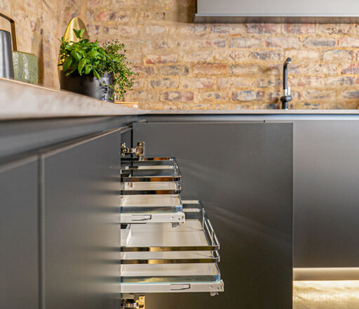 HUS - Our Kitchen Spaces, Graphite Sige pull-out shelf system showcasing innovative functionality and warm white LED strip lights.